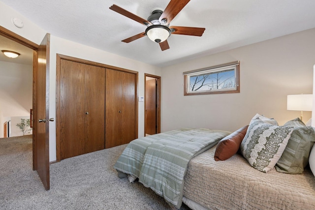 carpeted bedroom featuring a closet, a textured ceiling, and a ceiling fan