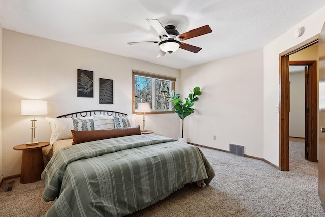 bedroom with a ceiling fan, baseboards, visible vents, carpet floors, and a textured ceiling