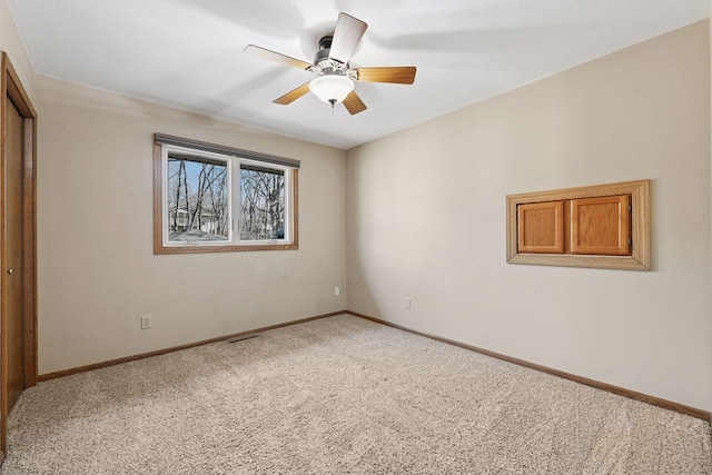 unfurnished room featuring carpet flooring, ceiling fan, and baseboards