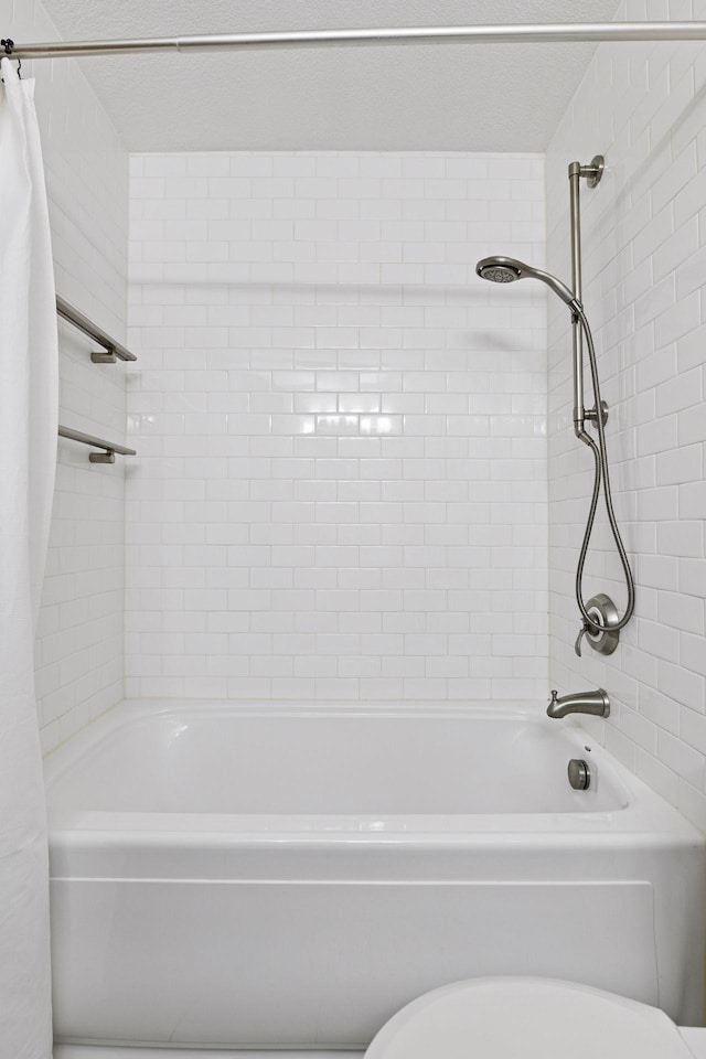 bathroom featuring shower / bath combination with curtain and toilet