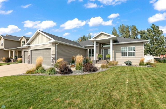 view of front of home featuring stone siding, a front yard, concrete driveway, and an attached garage