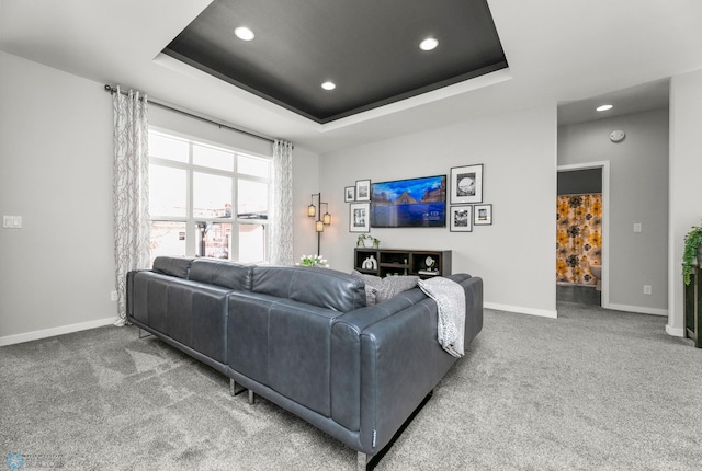 living area featuring recessed lighting, a raised ceiling, carpet flooring, and baseboards