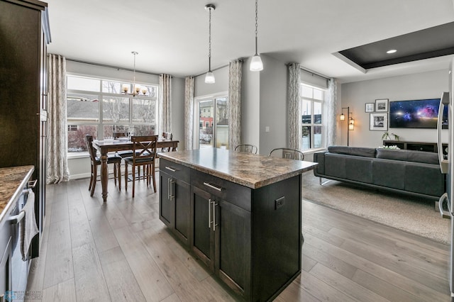 kitchen with light wood finished floors, a wealth of natural light, and a center island