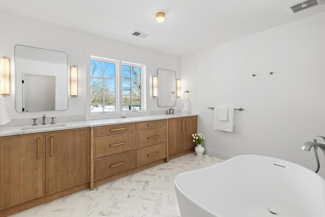 full bath with double vanity, a soaking tub, a sink, and visible vents