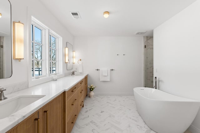 bathroom with marble finish floor, a shower stall, visible vents, and a sink