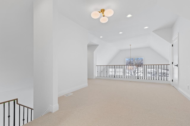 bonus room with lofted ceiling, carpet flooring, visible vents, and a notable chandelier