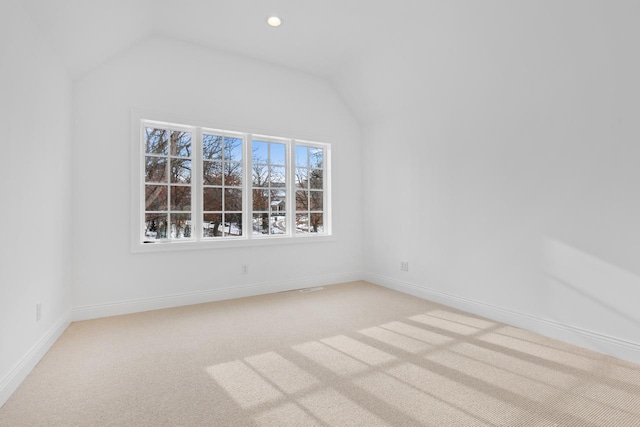 unfurnished room featuring recessed lighting, light colored carpet, vaulted ceiling, and baseboards