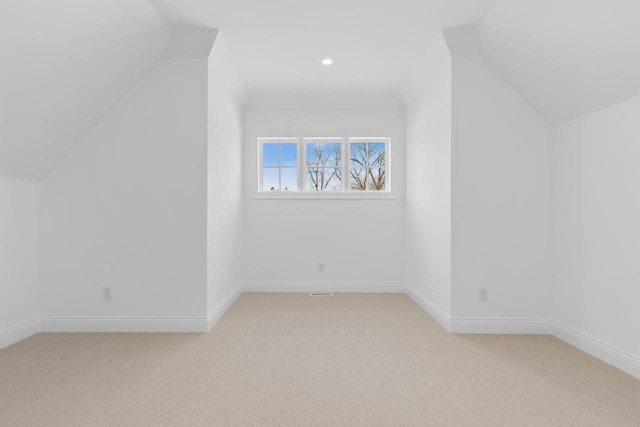 bonus room featuring light carpet, vaulted ceiling, and baseboards