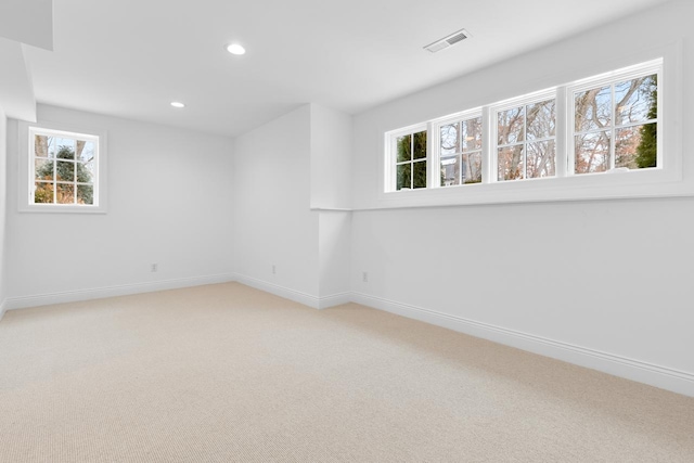 empty room featuring light carpet, recessed lighting, visible vents, and baseboards