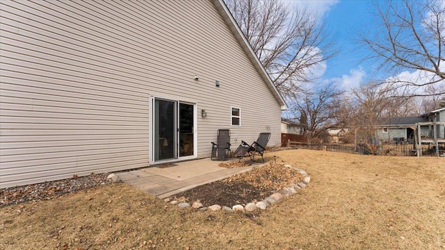 rear view of property featuring fence, a patio, and a yard