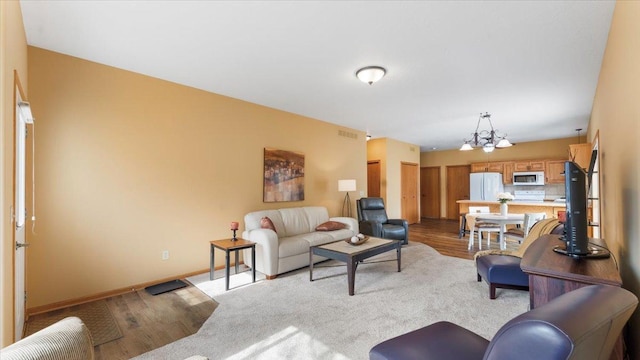 living room featuring visible vents, baseboards, and an inviting chandelier