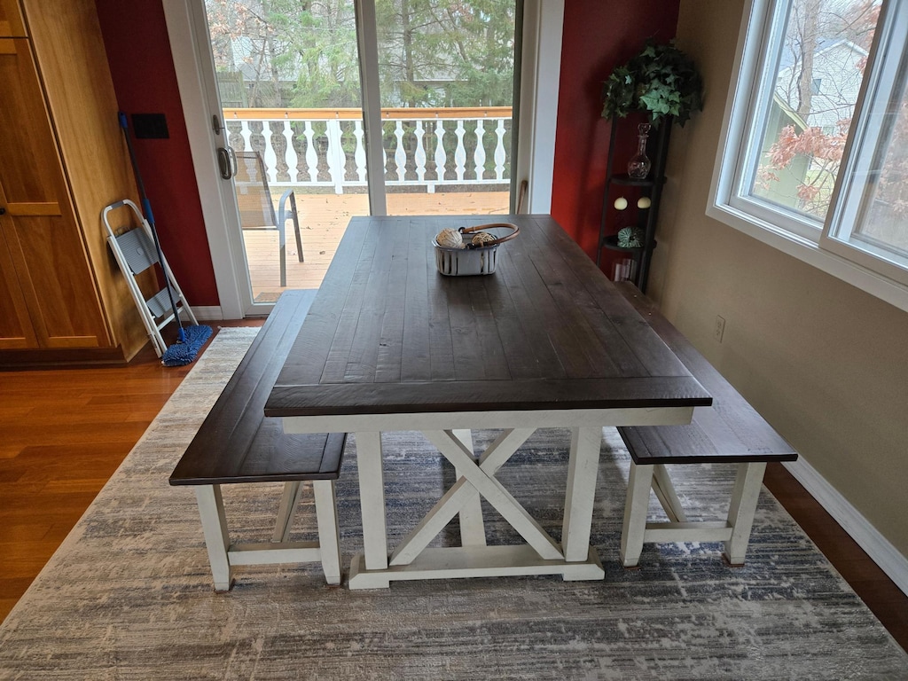 unfurnished dining area featuring baseboards and wood finished floors