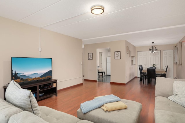 living room with a notable chandelier, wood finished floors, and baseboards