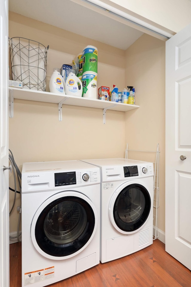 laundry area with washer and dryer, wood finished floors, and laundry area