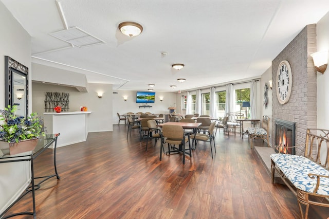 dining room with wood finished floors and a fireplace