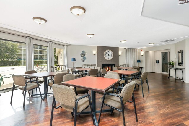 dining room featuring a fireplace, wood finished floors, and visible vents