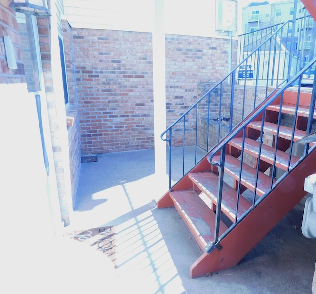 stairs featuring brick wall