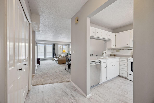 kitchen with white electric range oven, decorative backsplash, open floor plan, light countertops, and stainless steel dishwasher