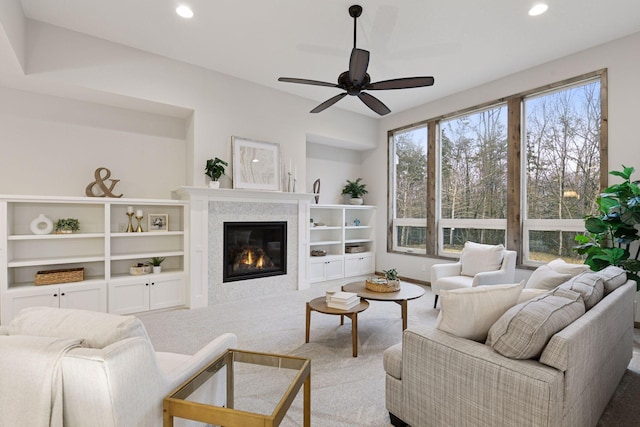 carpeted living room featuring ceiling fan, a glass covered fireplace, and recessed lighting