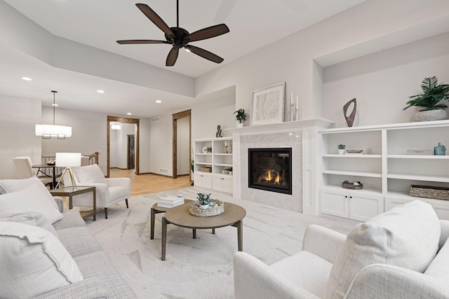 living room featuring a high end fireplace, recessed lighting, visible vents, and ceiling fan