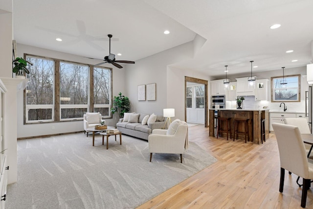 living room with light wood-style floors, recessed lighting, and plenty of natural light