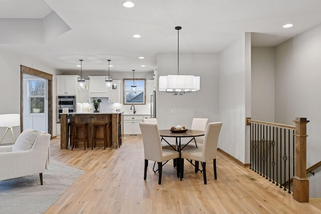 dining area featuring light wood-style flooring, baseboards, and recessed lighting