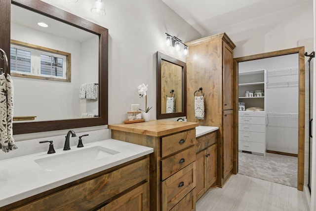 full bathroom with a spacious closet and vanity