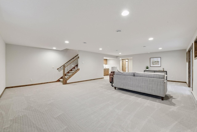 living area with recessed lighting, light carpet, baseboards, and stairs