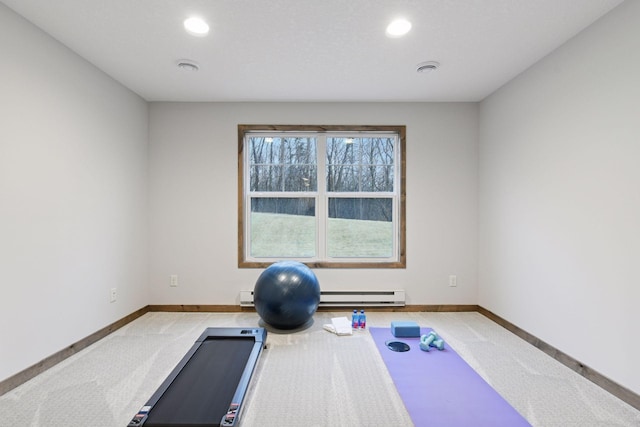 workout area with a baseboard heating unit, carpet, and baseboards