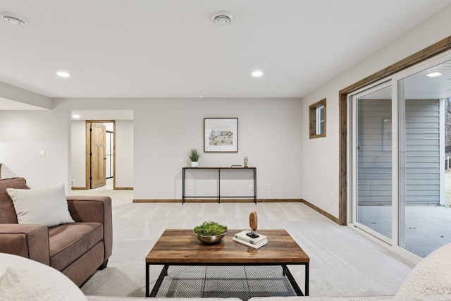 living room featuring recessed lighting, light colored carpet, and baseboards