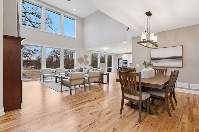 18928 Katrine Ct, Lakeville, MN 55044 - dining area featuring a chandelier, a towering ceiling, light wood-style flooring, baseboards, and recessed lighting