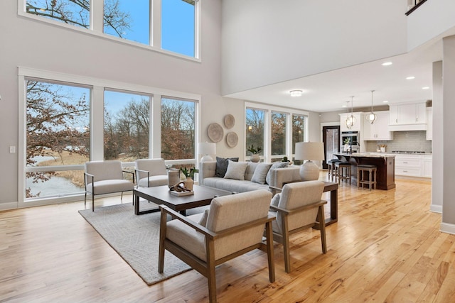 18928 Katrine Ct, Lakeville, MN 55044 - living area with a high ceiling, light wood-style flooring, recessed lighting, and baseboards