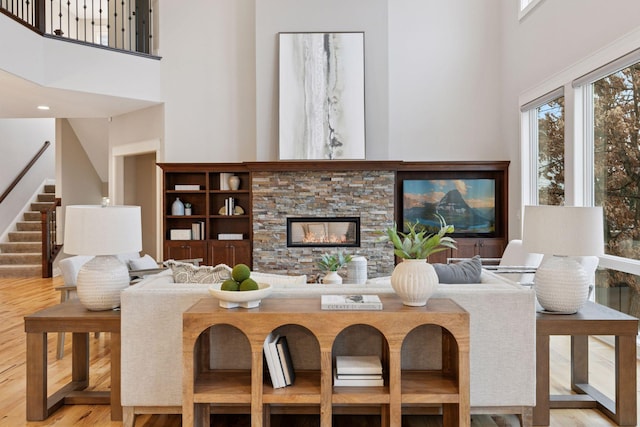18928 Katrine Ct, Lakeville, MN 55044 - living area featuring a high ceiling, stairs, wood finished floors, and a stone fireplace