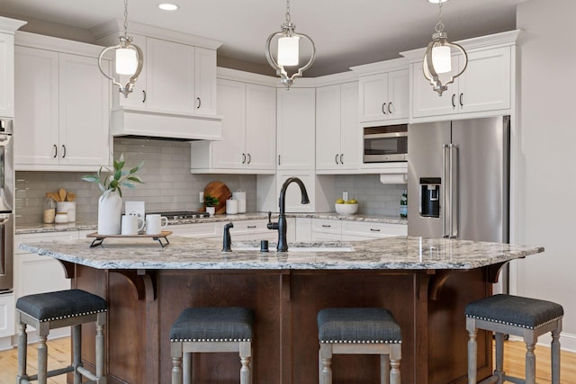18928 Katrine Ct, Lakeville, MN 55044 - kitchen with light wood-style floors, a sink, appliances with stainless steel finishes, white cabinets, and recessed lighting