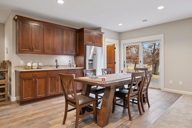18928 Katrine Ct, Lakeville, MN 55044 - dining space with light wood-style floors, baseboards, recessed lighting, and bar with sink
