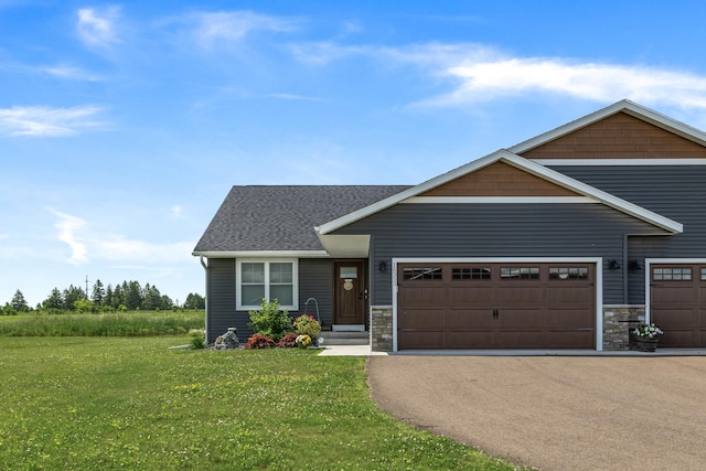 craftsman house featuring a front yard, a shingled roof, a garage, stone siding, and aphalt driveway