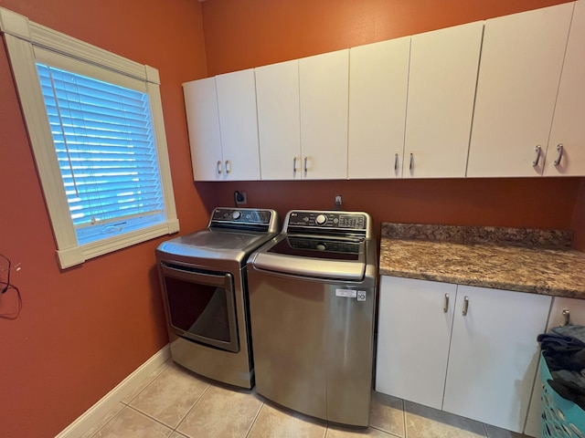 laundry room featuring cabinet space, light tile patterned floors, baseboards, and washer and dryer