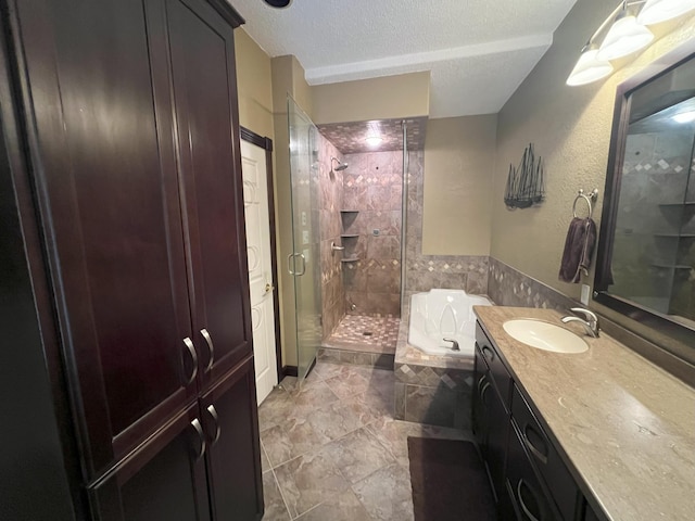 bathroom featuring a textured ceiling, a stall shower, vanity, and a bath