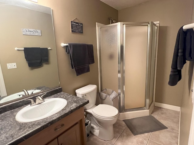 full bathroom featuring a stall shower, vanity, toilet, and tile patterned floors