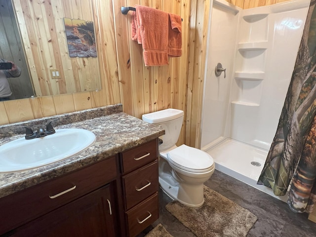 bathroom with toilet, a stall shower, vanity, and wooden walls