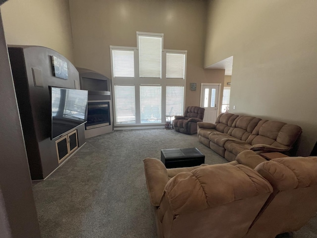 living area featuring carpet floors and a towering ceiling