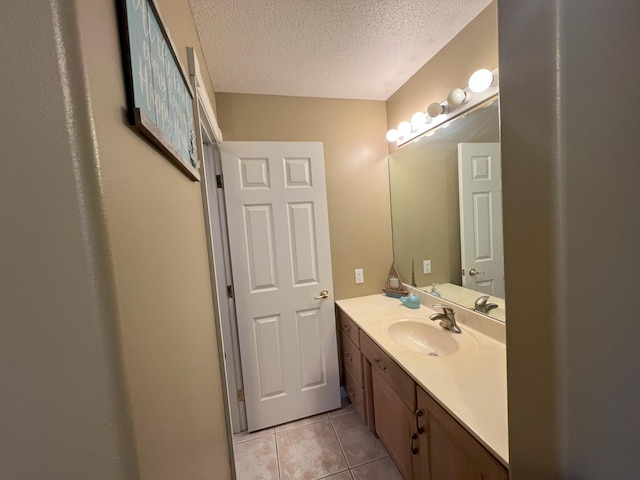 bathroom with tile patterned flooring, a textured ceiling, and vanity