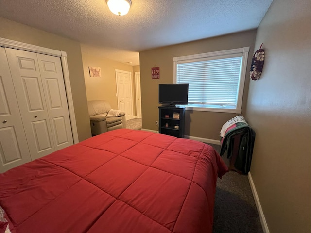 bedroom featuring a textured ceiling, a closet, carpet, and baseboards