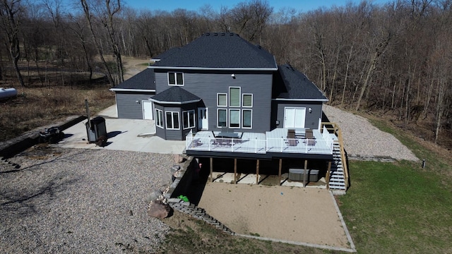 11999 Lake Maud Trl, Lake Eunice Twp, MN 56511 - rear view of house featuring a forest view, a wooden deck, stairway, and a patio