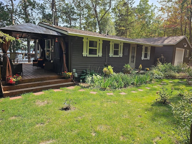 ranch-style house with a deck, a gazebo, a front yard, and a garage