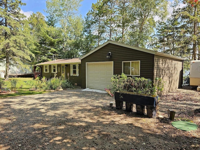 single story home with dirt driveway and a garage