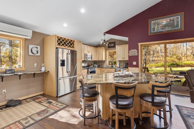 kitchen with dark wood-style flooring, stainless steel appliances, a wall mounted AC, vaulted ceiling, and dark stone countertops