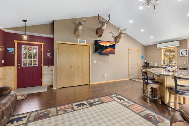 living area featuring vaulted ceiling, a wall unit AC, dark wood finished floors, and visible vents