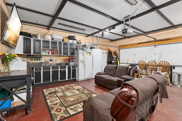 garage featuring white fridge with ice dispenser and a garage door opener