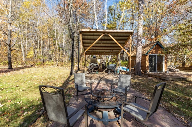 view of patio featuring an outbuilding and an outdoor fire pit